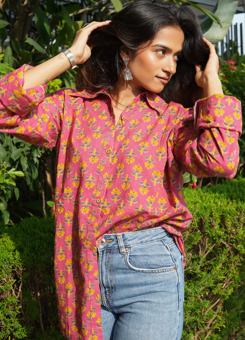 Woman wearing a Gulnaar shirt and blue jeans outdoors.