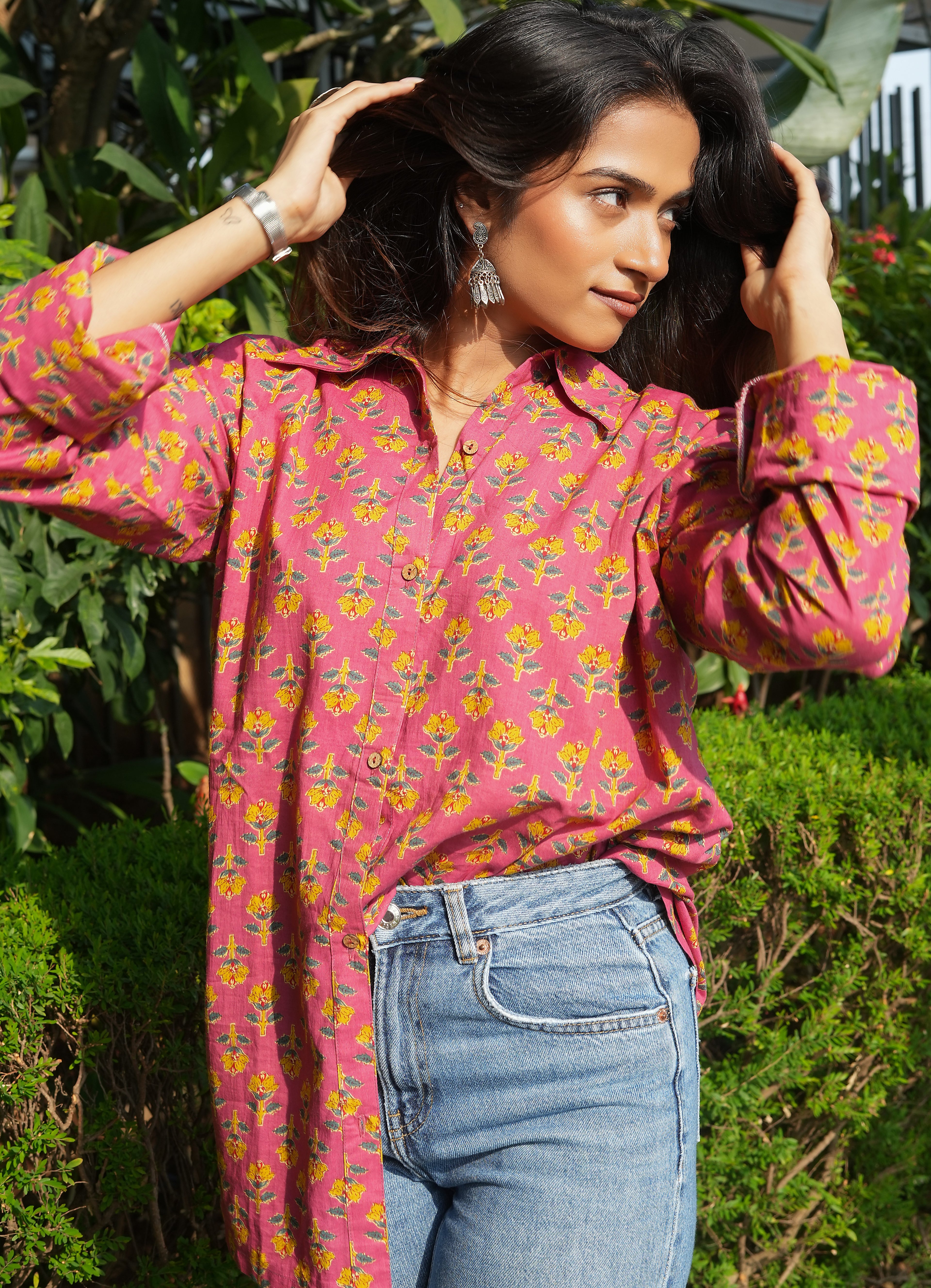Woman wearing a Gulnaar shirt and blue jeans outdoors.