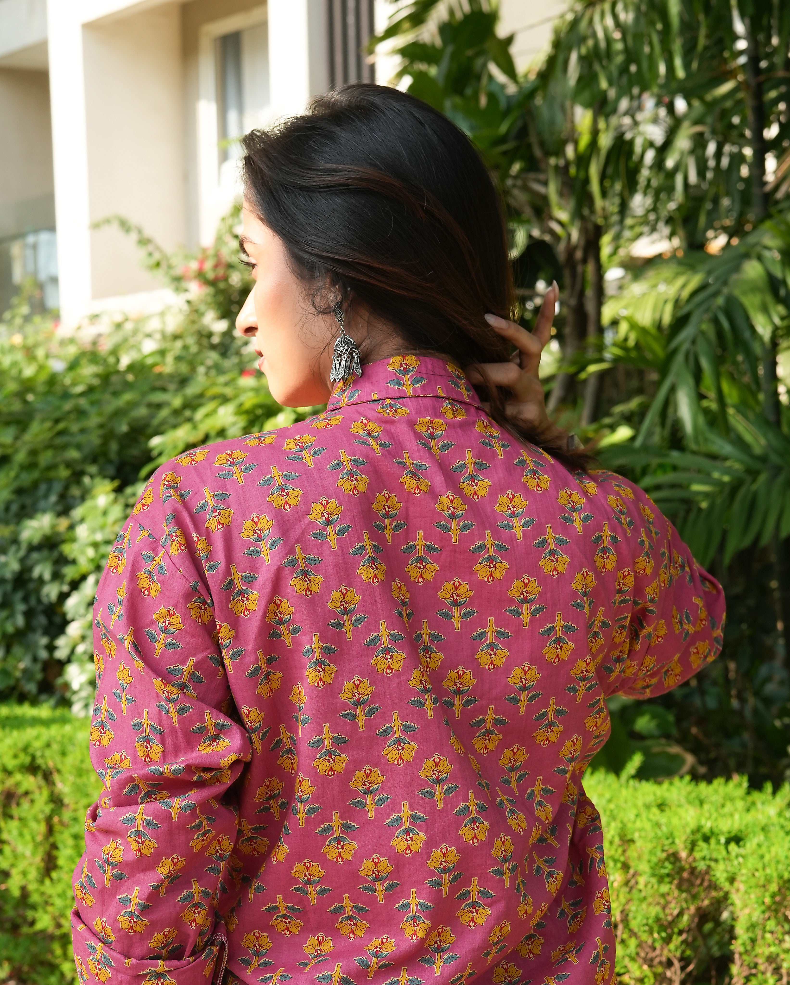 Woman wearing a Gulnaar shirt outdoors with greenery in the background