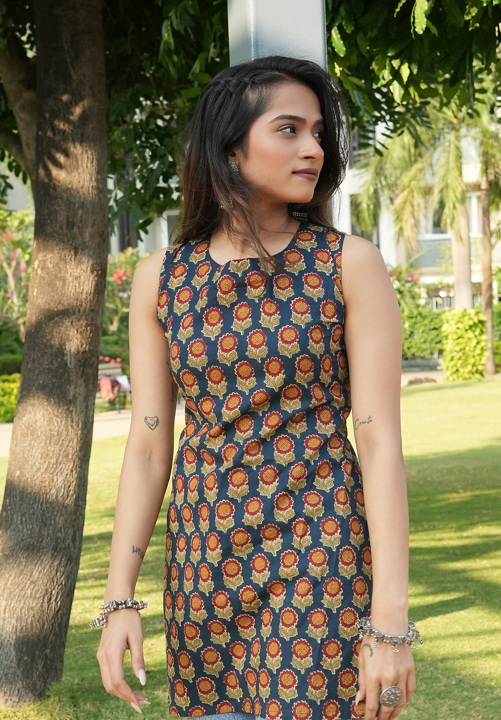 Woman wearing a Noor kurta 
standing outdoors with greenery in the background