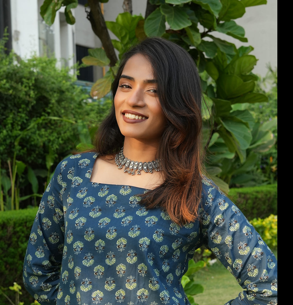 Woman wearing a Teal lace up Kurti dress with greenery in the background