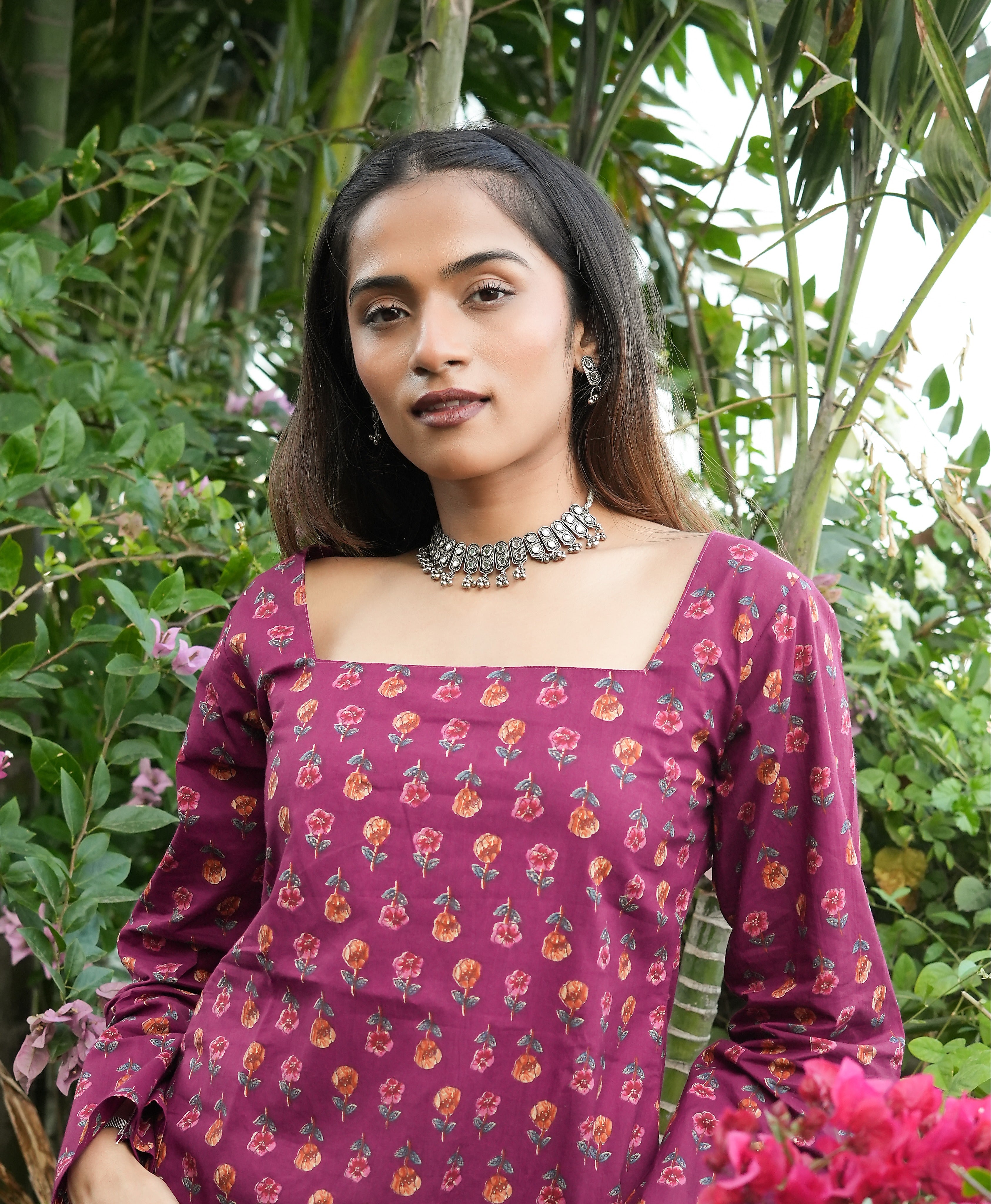 Woman wearing a Wine blossom kurti dress with greenery in the background