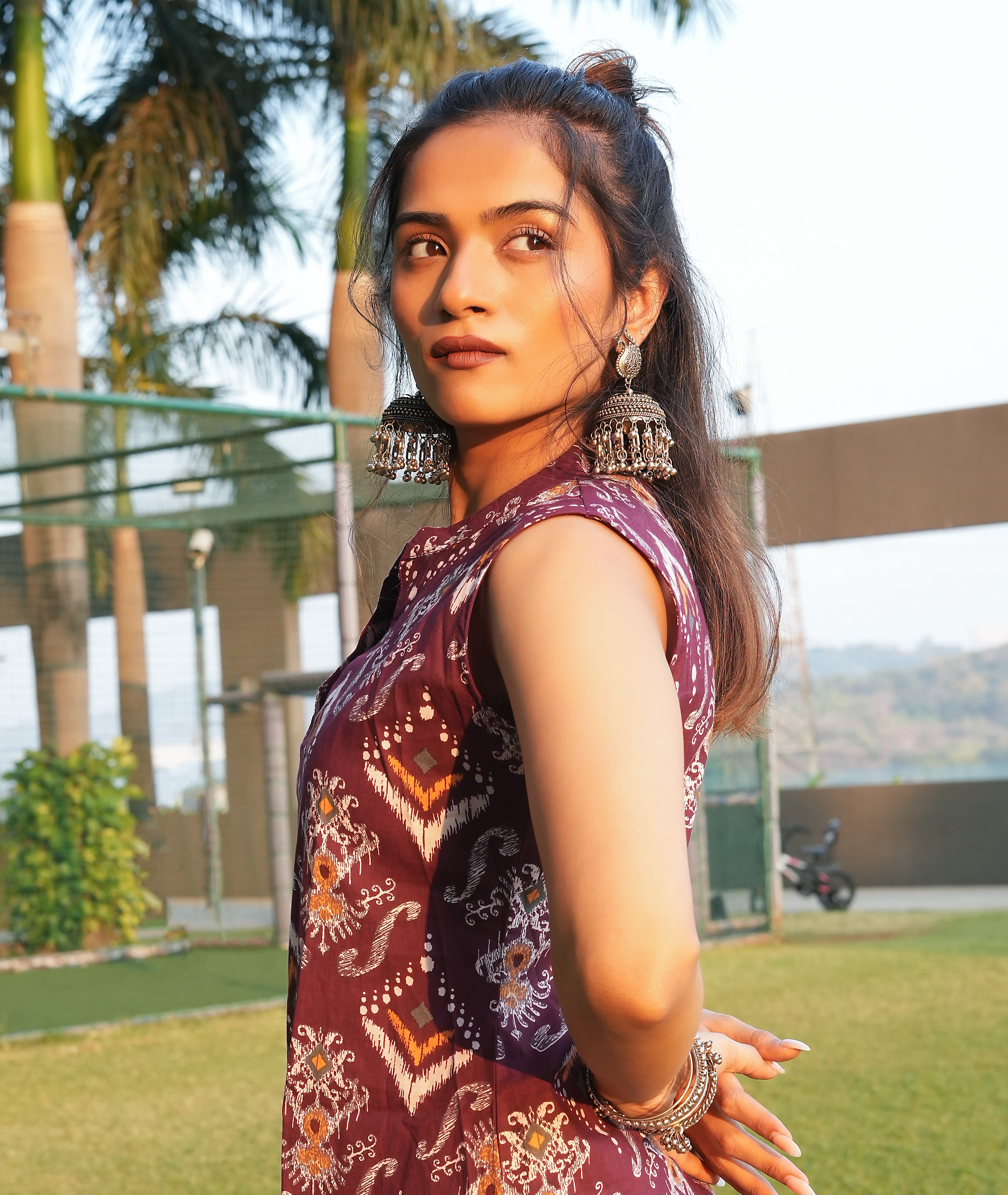 Woman wearing a Maroon ikat kurti with earrings outdoors