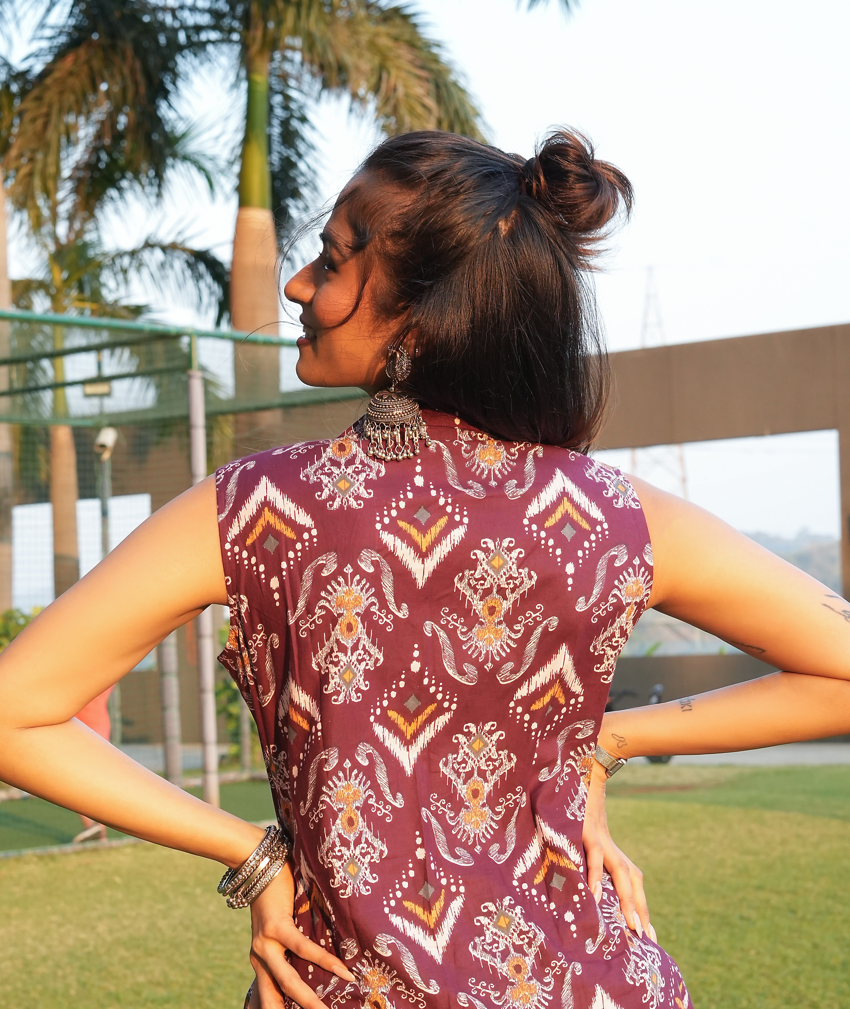 Woman wearing a Maroon ikat kurti with a blurred outdoor background