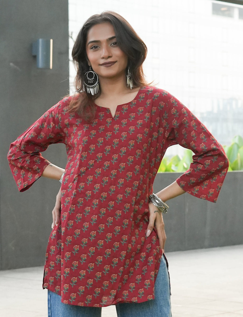 Woman wearing a Laal kurta with blue jeans outdoors.