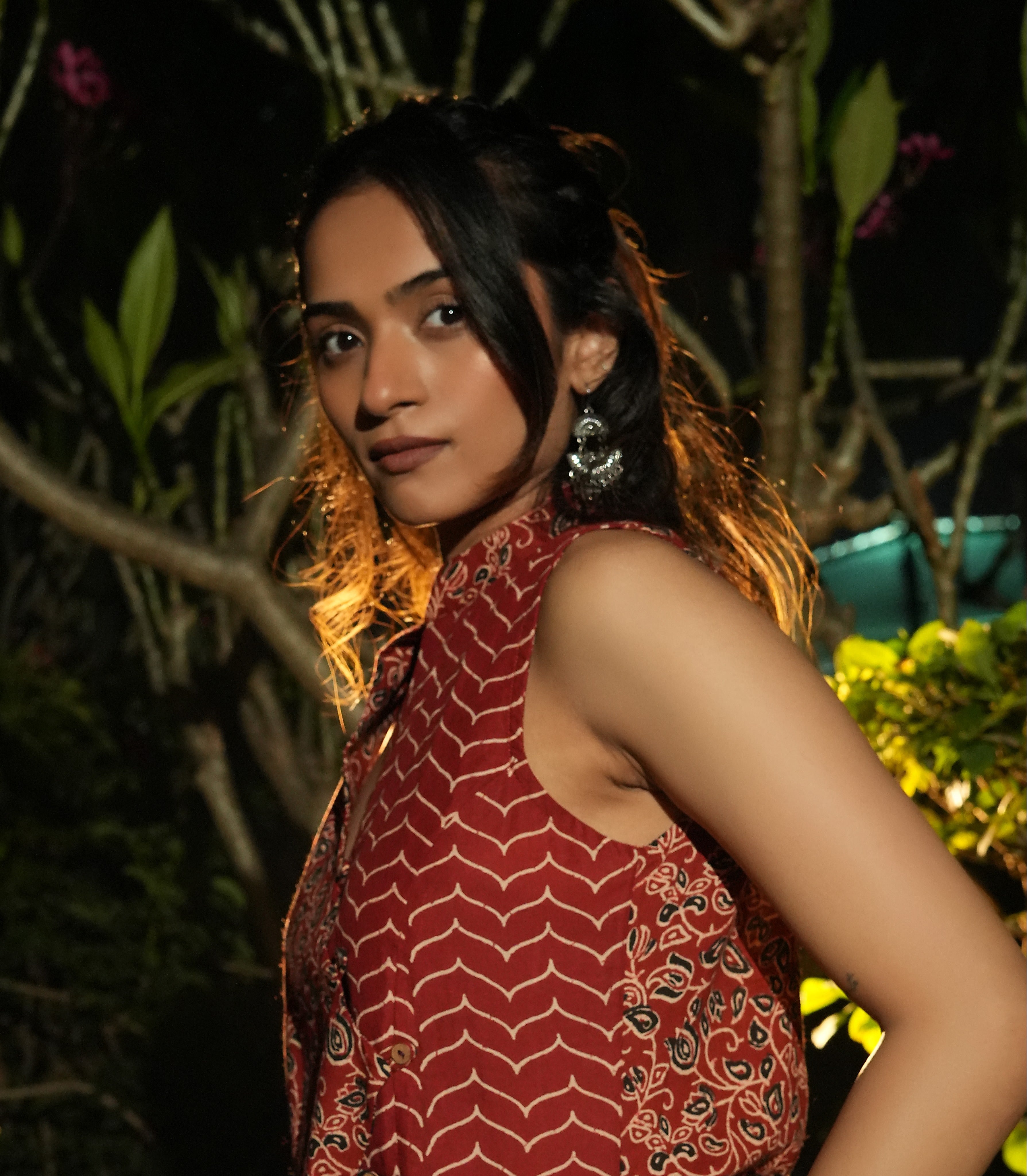 Woman wearing aMaroon overlap top with a blurred natural background